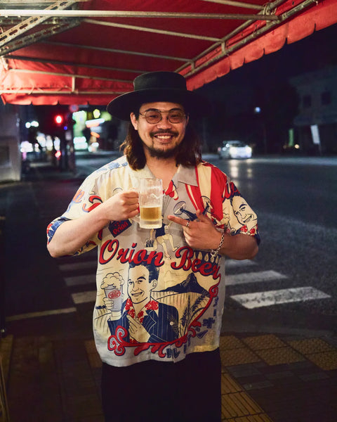 Eanbeアロハ『CARRY』を着用してオリオンビールで乾杯を掲げる様子